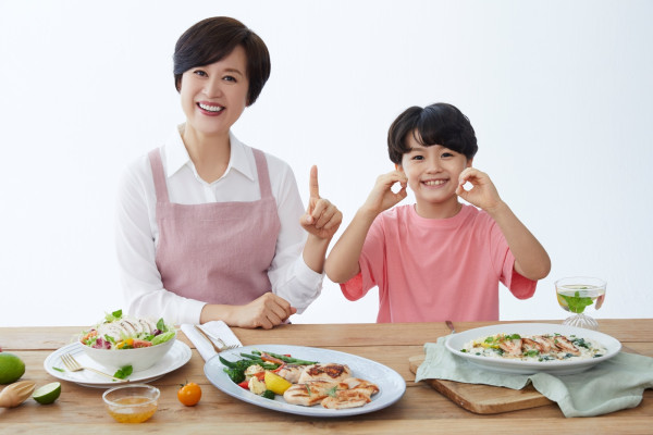 CJ제일제당 The더건강한 닭가슴살로 만든 요리와 함께 박미선과 어린이 모델이 포즈를 취하고 있다